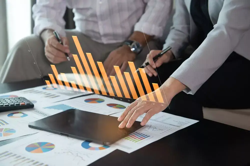 Business team using laptop computer with financial report spreadsheet virtual screen interface for business performance evaluation 